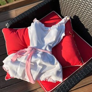 Vintage skirted bathing suit. White pinup style suit with pink edging, ruffles.